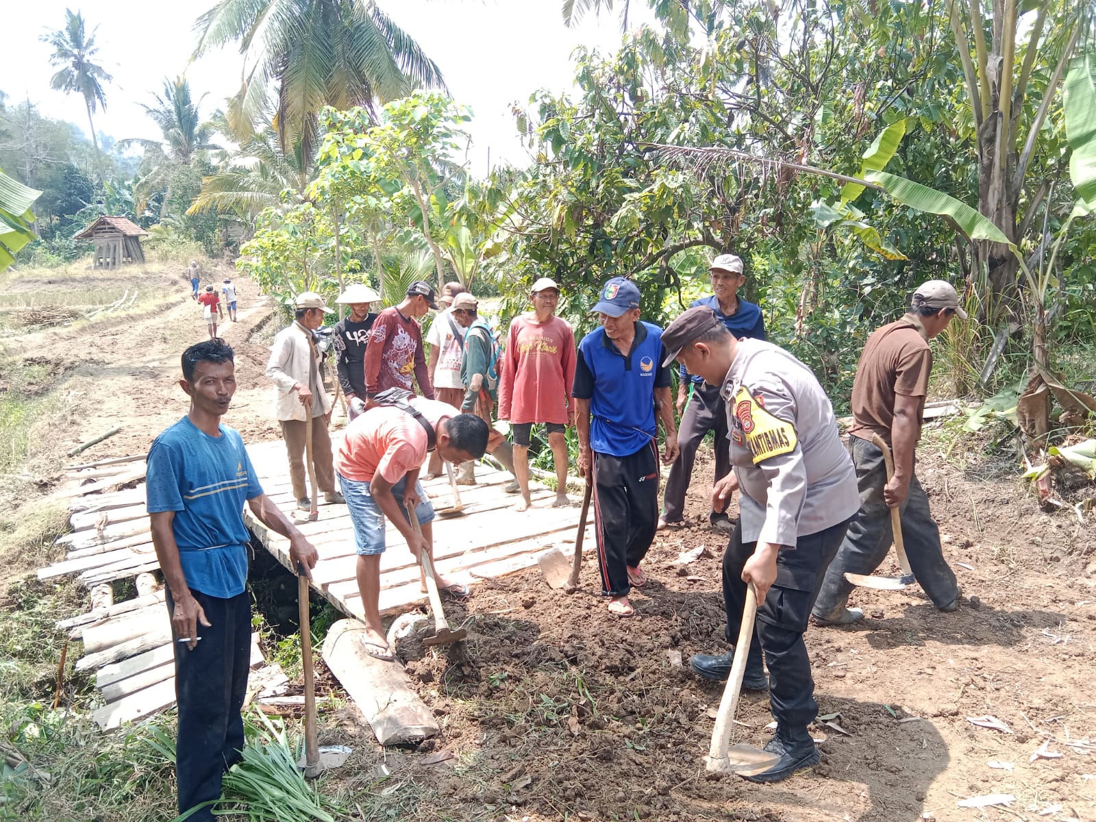 Bhabinkamtibmas Polsek Pugung Bersama Warga Gotong Royong Perbaiki Jembatan dan Lebarkan Jalan